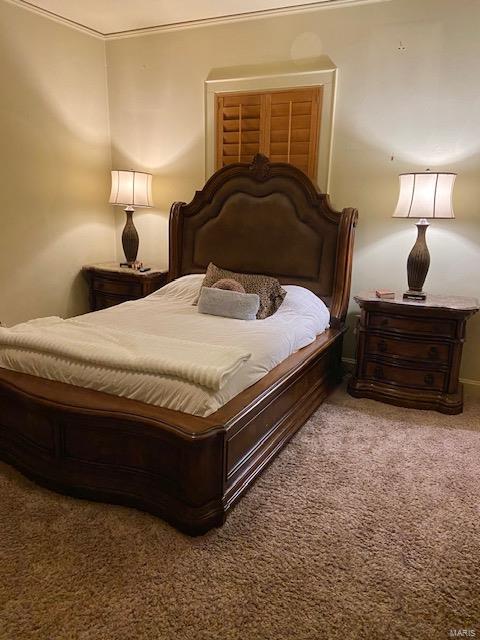 carpeted bedroom with ornamental molding