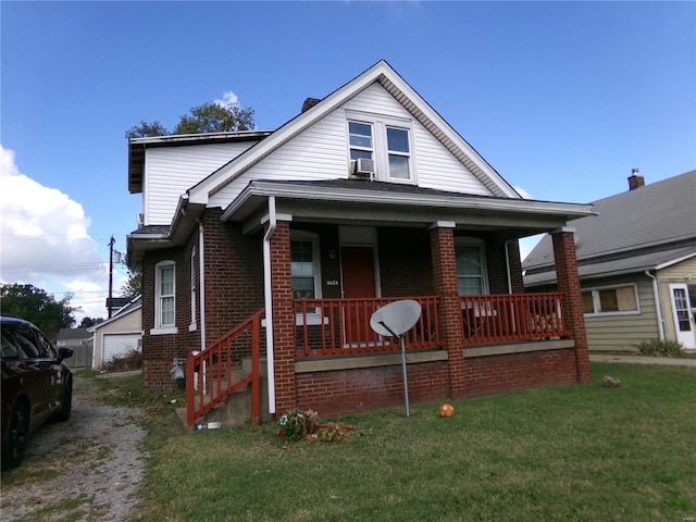 bungalow-style home featuring a porch, brick siding, and a front yard