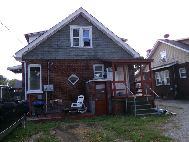 rear view of house with brick siding and a patio
