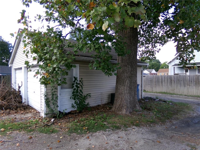 view of side of property featuring a garage and fence