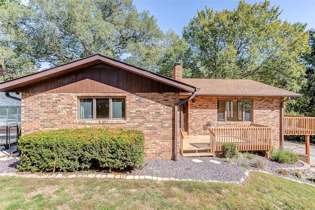 ranch-style home featuring a wooden deck and a front lawn