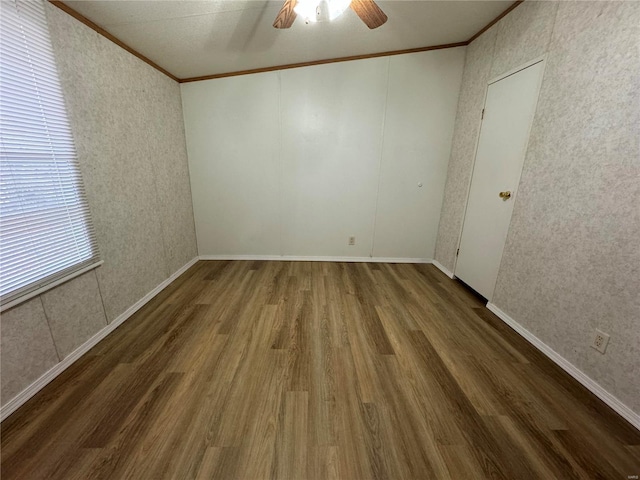 unfurnished room featuring dark hardwood / wood-style floors, ceiling fan, and ornamental molding