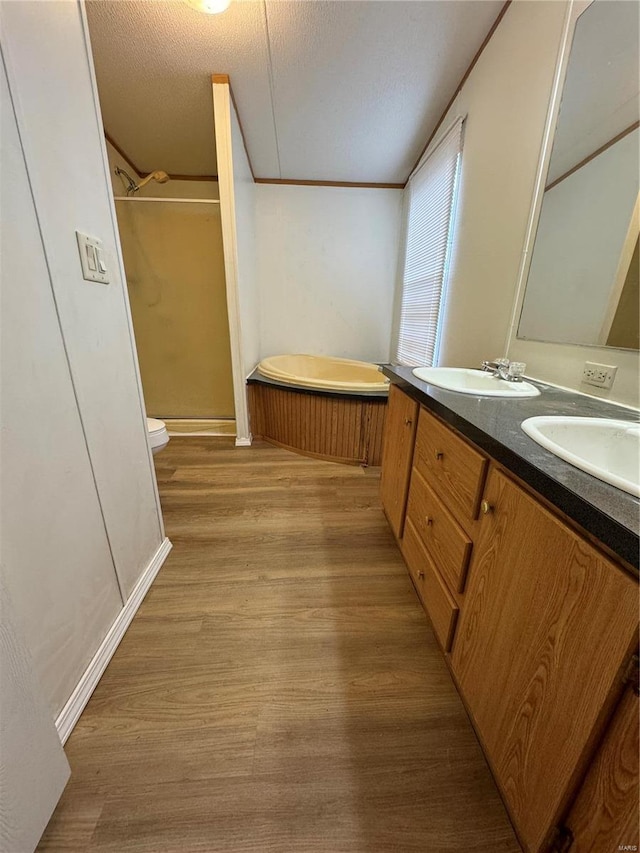 full bathroom featuring vanity, shower with separate bathtub, a textured ceiling, and hardwood / wood-style flooring