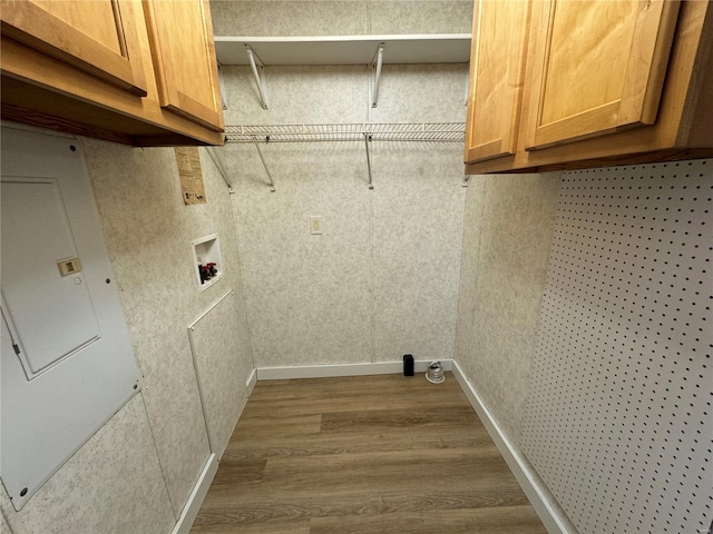 clothes washing area featuring cabinets, wood-type flooring, and hookup for a washing machine