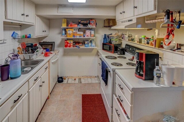 kitchen with white appliances, white cabinetry, light tile patterned flooring, and backsplash