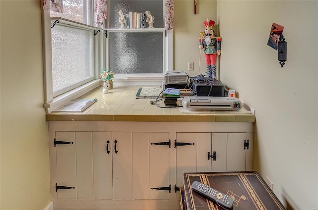 kitchen featuring tile counters and white cabinets