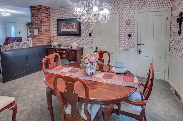 dining room with carpet floors and an inviting chandelier