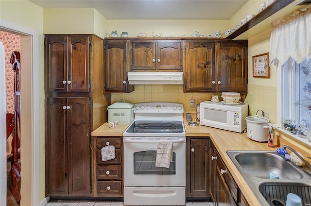 kitchen featuring backsplash, white appliances, light tile patterned flooring, and sink