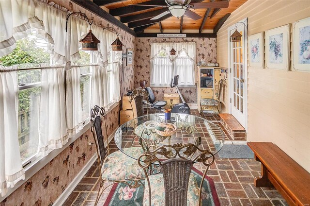 unfurnished dining area featuring vaulted ceiling with beams, a healthy amount of sunlight, wood ceiling, and ceiling fan