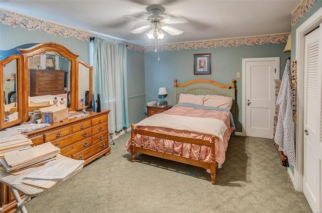 carpeted bedroom with ceiling fan and a closet