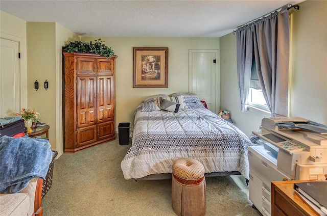 bedroom featuring a textured ceiling and light colored carpet