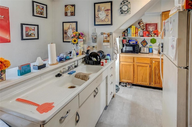 kitchen with light tile patterned floors and white fridge