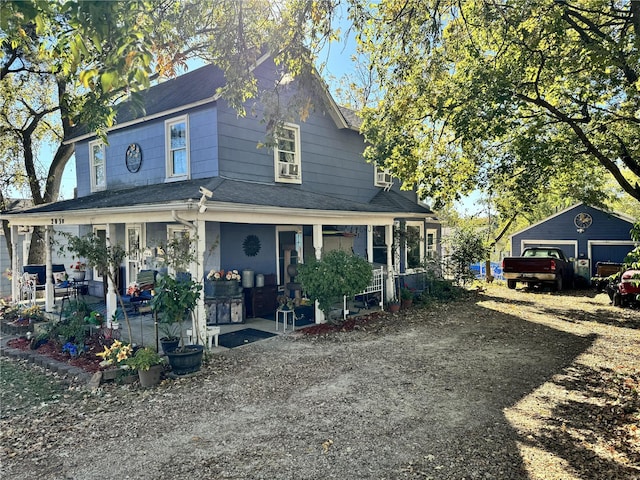 view of front facade featuring a porch, an outbuilding, and a garage