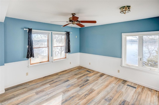 unfurnished room with ceiling fan and light wood-type flooring