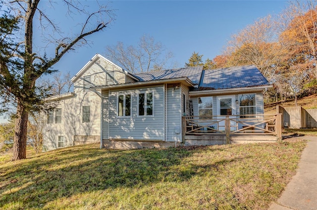 view of front of home with a deck and a front yard