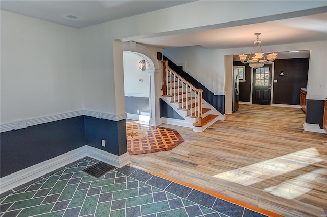 entrance foyer with hardwood / wood-style flooring and an inviting chandelier