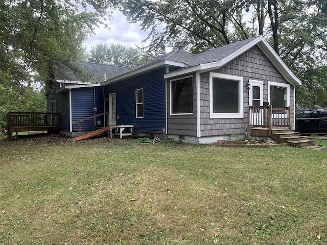 back of property with a wooden deck and a yard