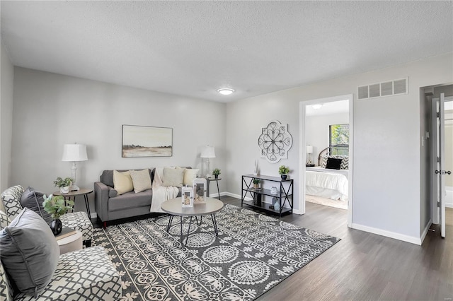 living room featuring a textured ceiling and dark hardwood / wood-style flooring