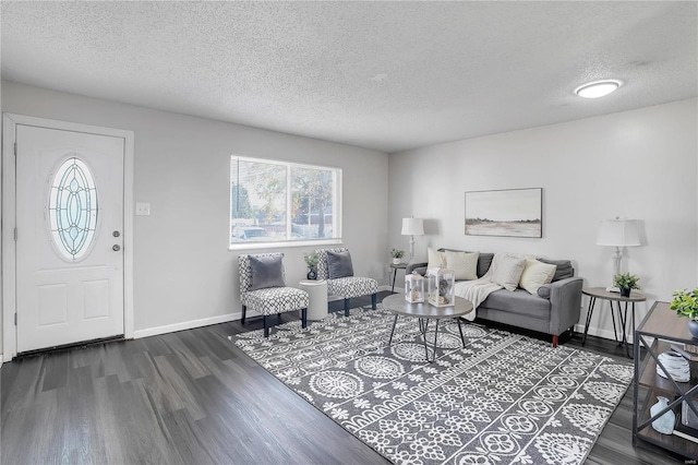 living room with a textured ceiling and dark hardwood / wood-style floors