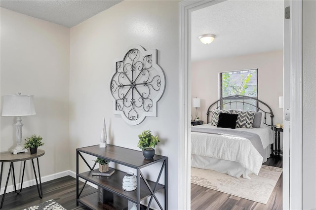 bedroom featuring a textured ceiling and dark hardwood / wood-style flooring