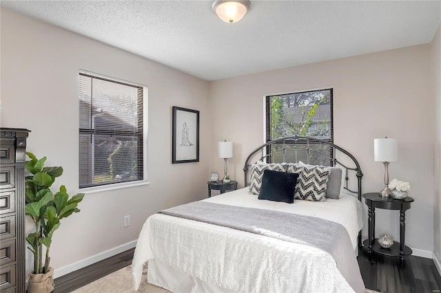 bedroom with dark wood-type flooring and a textured ceiling