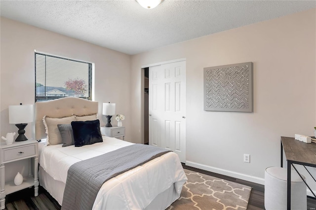 bedroom featuring a closet, a textured ceiling, and dark hardwood / wood-style flooring