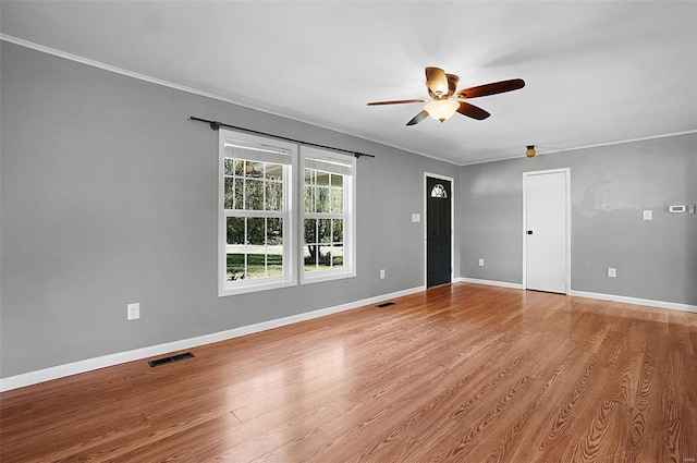 spare room featuring ceiling fan, hardwood / wood-style floors, and crown molding