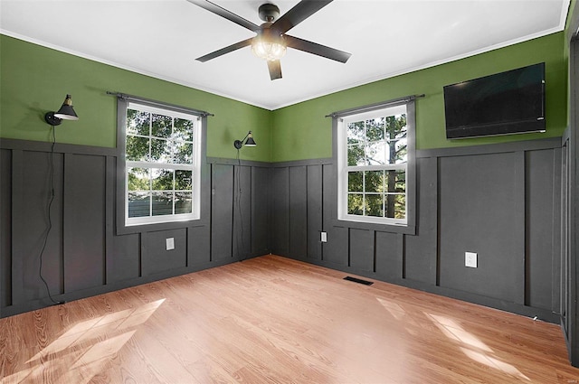 spare room featuring light hardwood / wood-style flooring, ceiling fan, and plenty of natural light