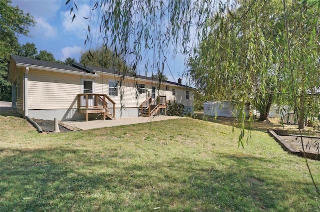 back of house with a deck and a yard