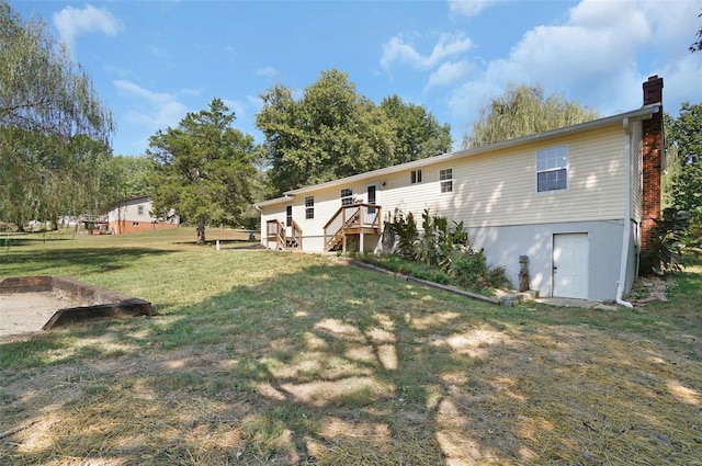 back of house with a deck and a yard