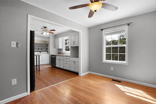 unfurnished bedroom with ceiling fan, light wood-type flooring, sink, and washing machine and clothes dryer