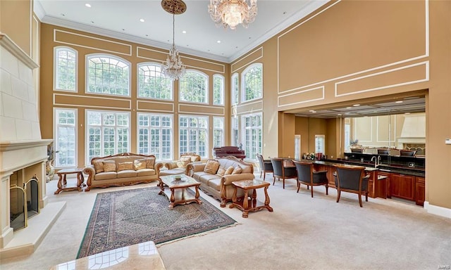 carpeted living room with a towering ceiling, a chandelier, and a wealth of natural light