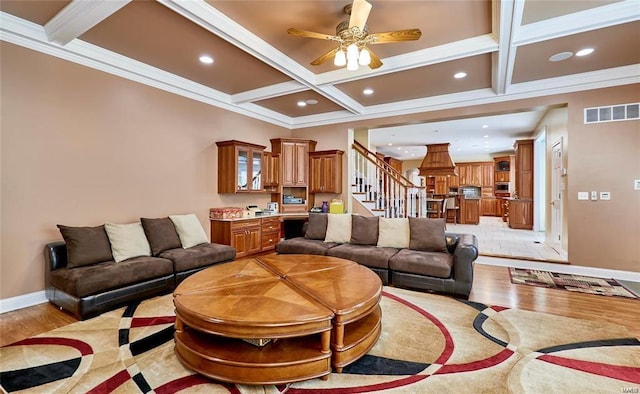 living room featuring light wood-type flooring, beamed ceiling, coffered ceiling, and ceiling fan