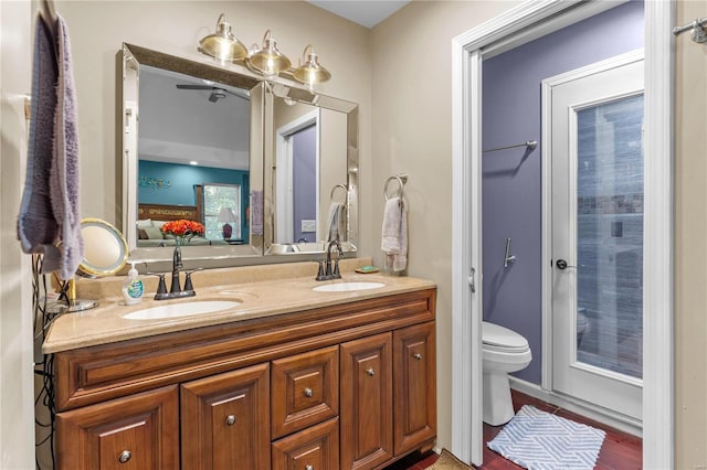 bathroom featuring wood-type flooring, vanity, and toilet