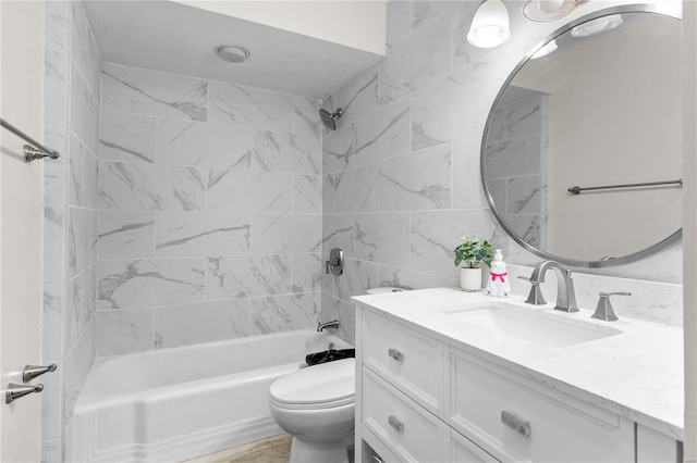 full bathroom featuring tile walls, tiled shower / bath combo, vanity, and toilet