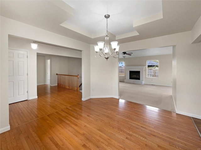 interior space featuring light wood-type flooring, a fireplace, and an inviting chandelier