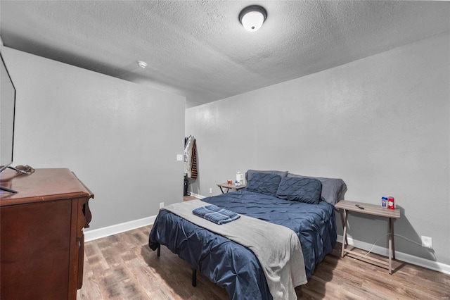 bedroom featuring a textured ceiling and hardwood / wood-style flooring