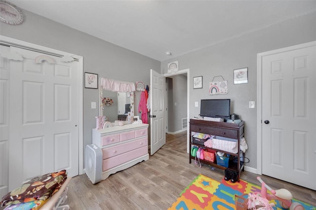 rec room with visible vents, light wood-style flooring, and baseboards