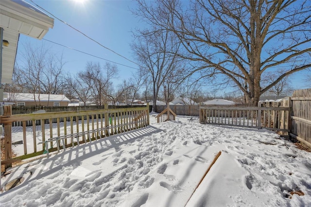 snow covered deck featuring a fenced backyard