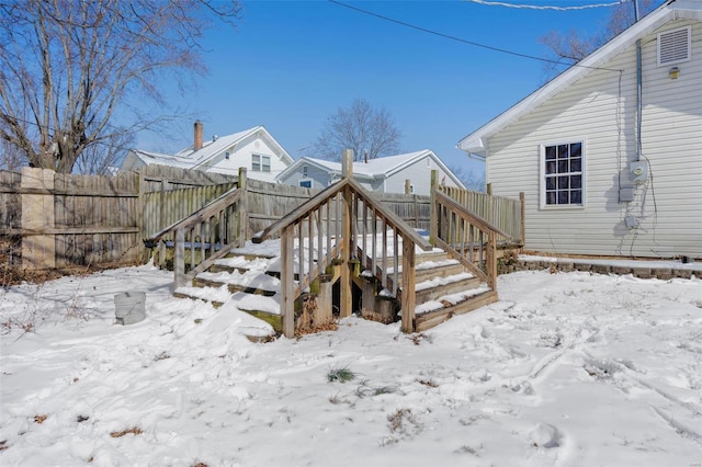 snow covered deck featuring a fenced backyard