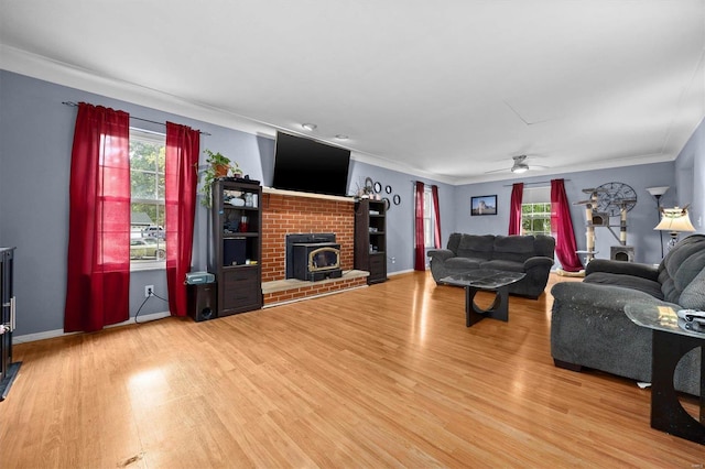 living room with ceiling fan, hardwood / wood-style flooring, a fireplace, and a healthy amount of sunlight