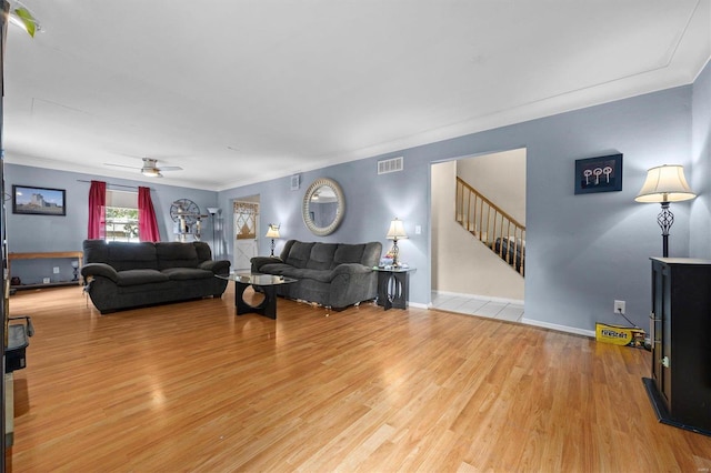 living room featuring ceiling fan, light wood-type flooring, and ornamental molding