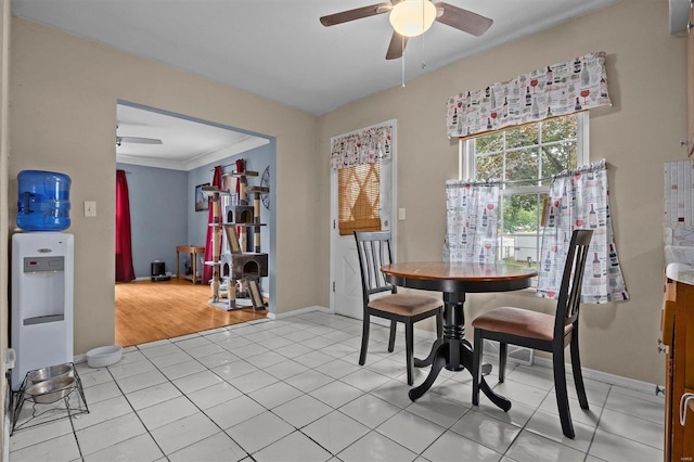 tiled dining area featuring ornamental molding and ceiling fan