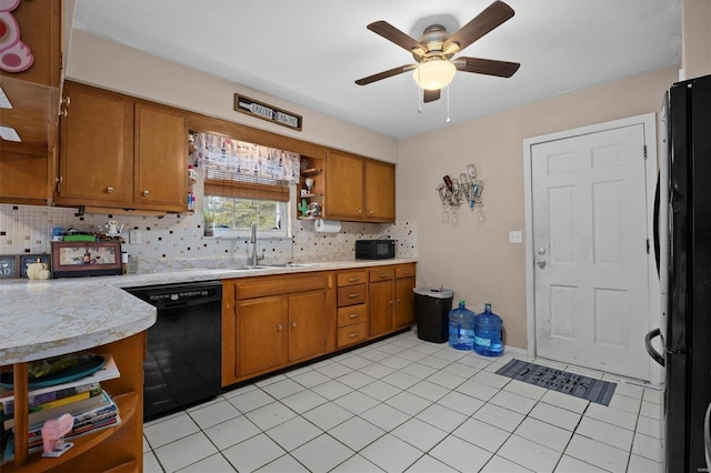 kitchen featuring sink, decorative backsplash, black appliances, light tile patterned floors, and ceiling fan