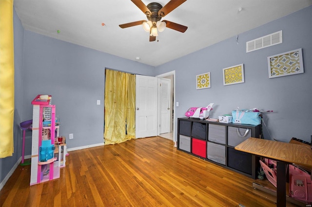 playroom with wood-type flooring and ceiling fan