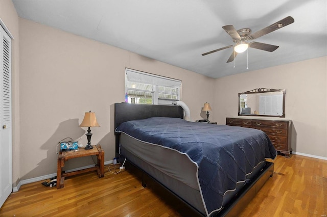 bedroom with a closet, light hardwood / wood-style floors, and ceiling fan