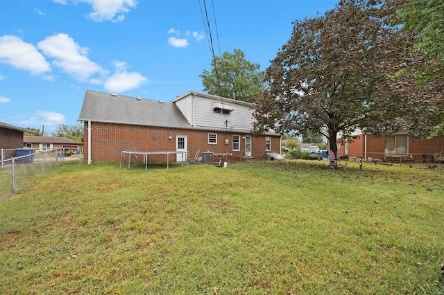 rear view of house featuring a lawn and cooling unit