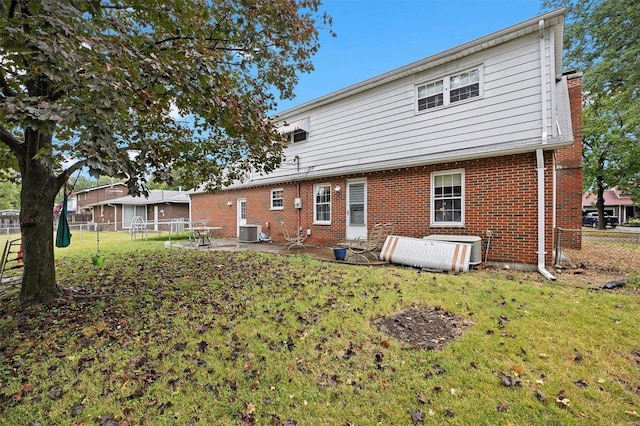 back of property with cooling unit, a patio area, and a yard