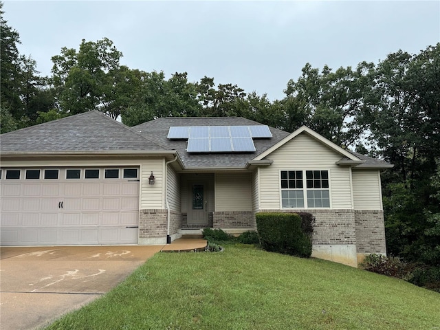 view of front of property featuring a front yard, a garage, and solar panels