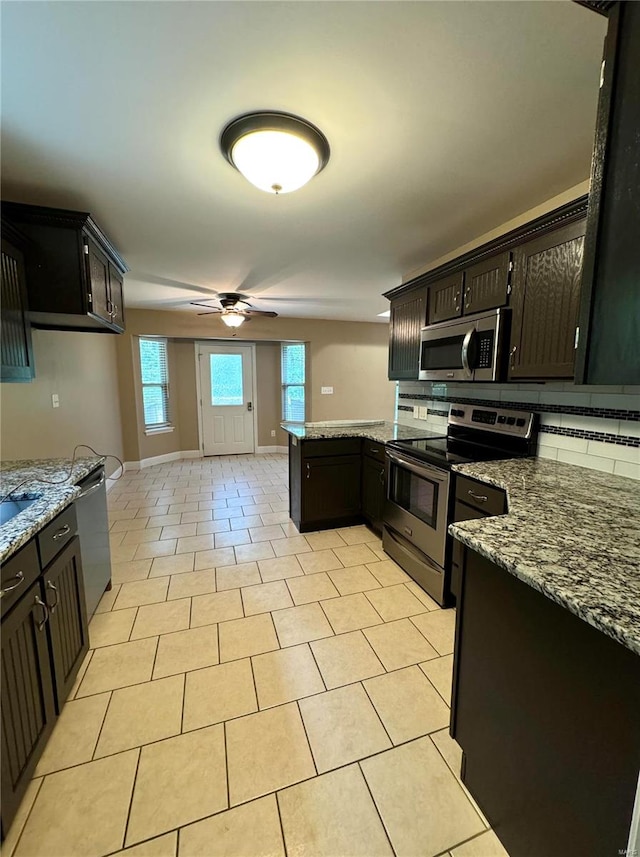 kitchen featuring light stone countertops, stainless steel appliances, ceiling fan, and tasteful backsplash